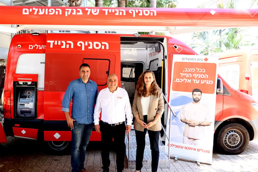 מימין: פזית גרפינקל, המשנה למנכ״ל והממונה על החטיבה הקמעונאית בבנק הפועלים, דודי יצחקי, מנהל מערך הסניפים הניידים של הבנק וכפיר רמז, מנהל אגף הסניפים בבנק על רקע הסניף הנייד של בנק הפועלים בכפר המכביה, צילום: אביב גוטליב