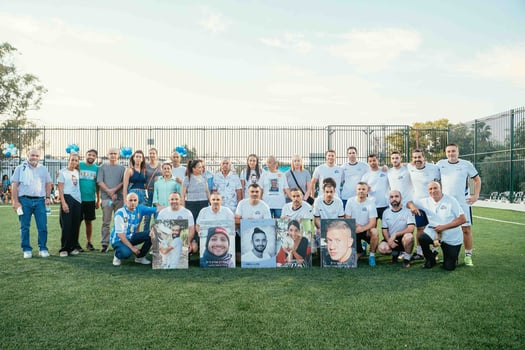 נבחרת איגוד מנהלי הפמילי אופיס עם נציגי משפחות הנרצחים, קרדיט: איגוד ה-IFO